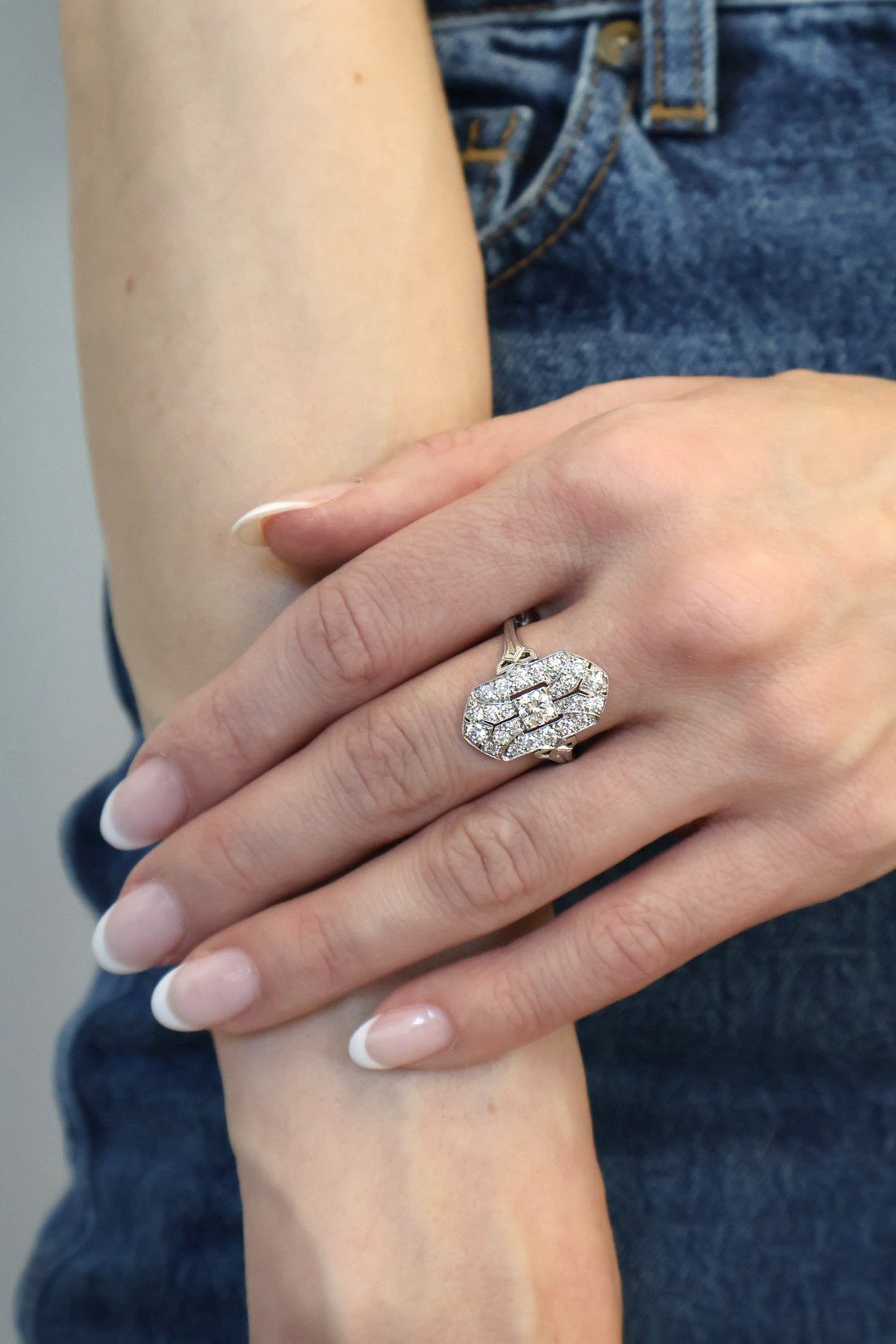 Art Deco Tiffany platinum and diamond navette shaped ring on hand in front of jeans