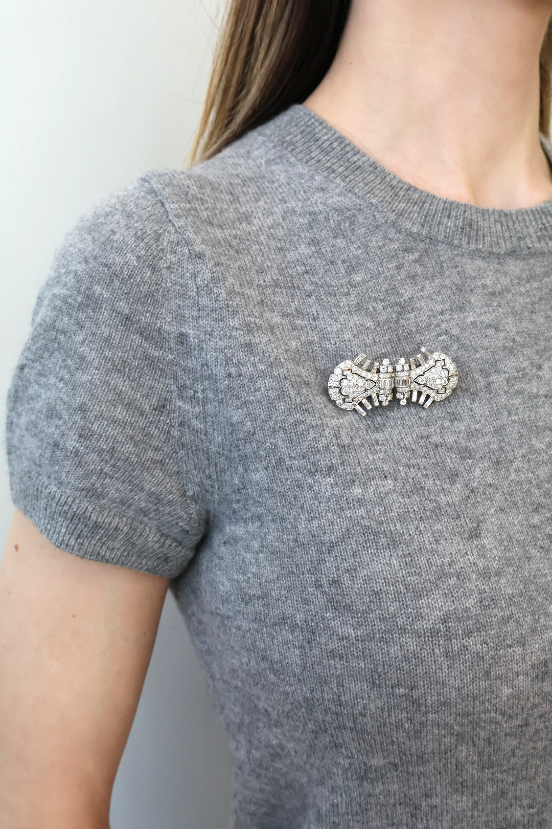 vintage cartier platinum and diamond double clips as single brooch on grey sweater