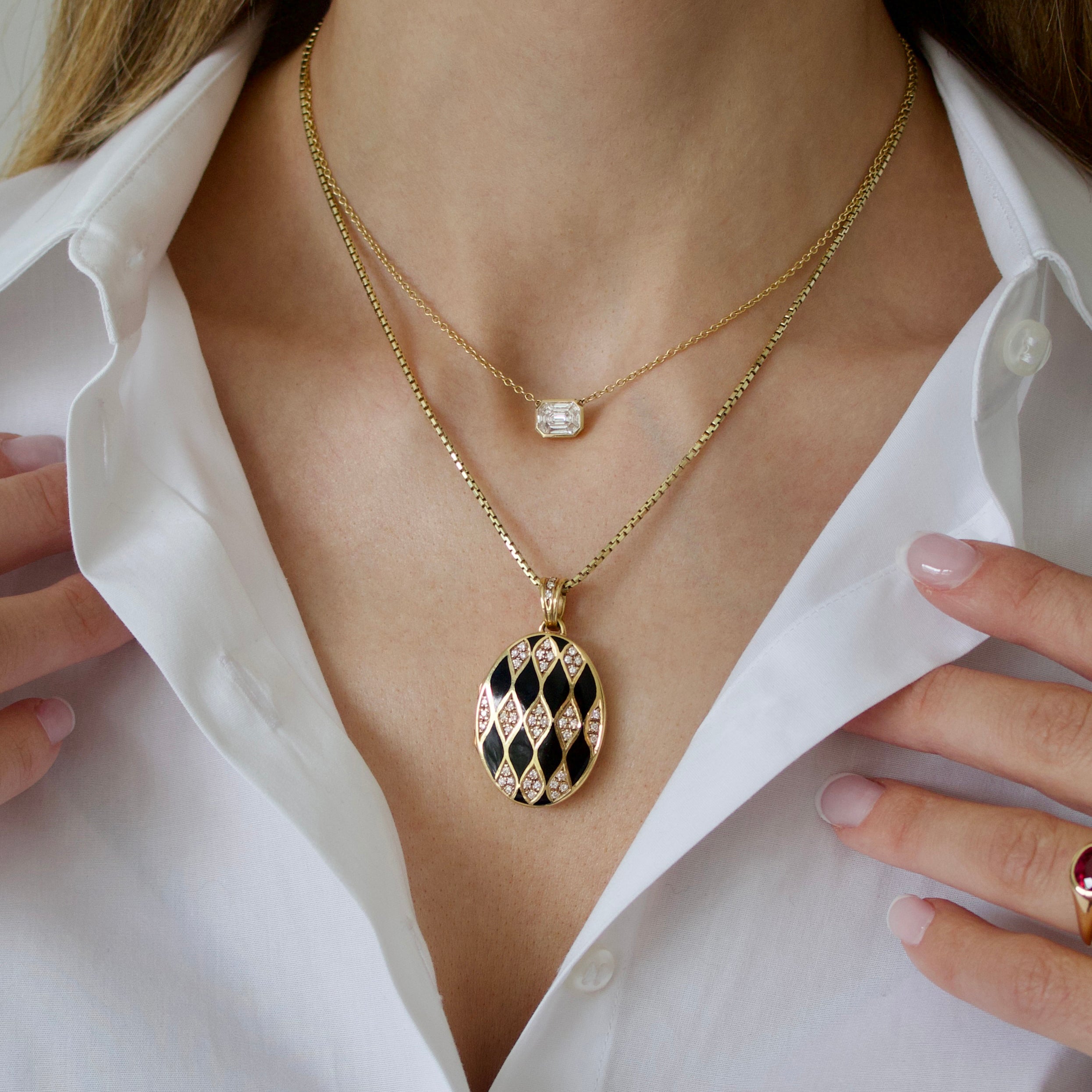Woman wearing 18kt yellow gold enamel locket necklace and diamond pendant necklace
