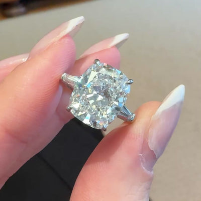Cushion diamond engagement ring on a hand with a neutral background