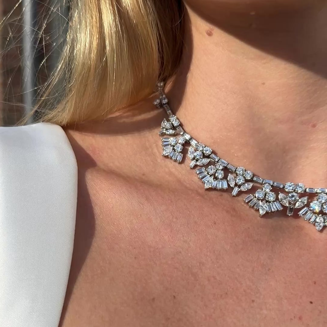 Video of vintage mid-century platinum and diamond necklace on a blond in a white dress