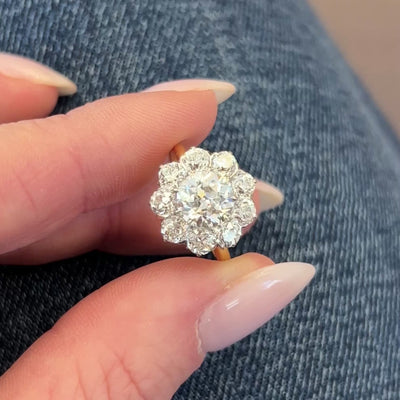 Round diamond engagement ring on a hand with a neutral background