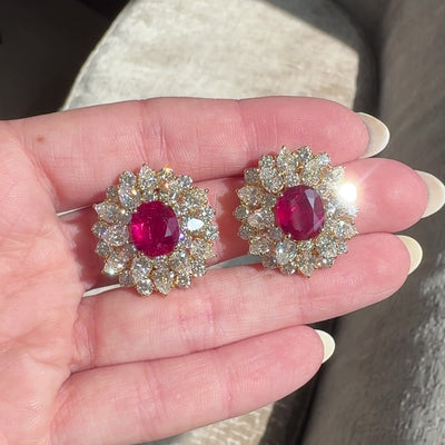 video of 18kt yellow gold ruby and diamond cluster earrings in hand sparkling in sunlight