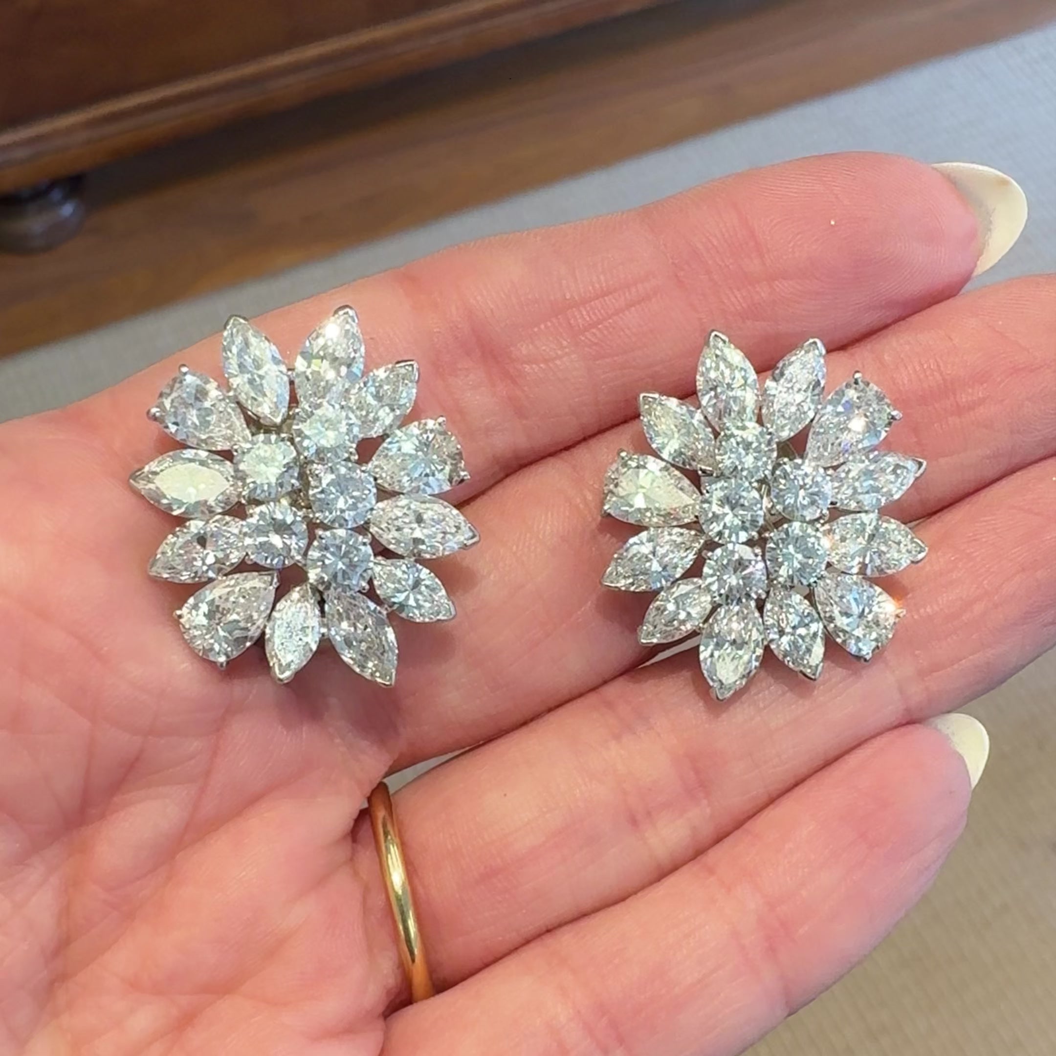 Platinum diamond cluster earrings, video of woman holding them in hand